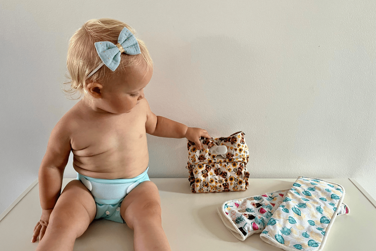 Bébé portant une couche lavable réutilisable, illustrant une solution écologique à faible impact en eau, énergie et sans PFAS